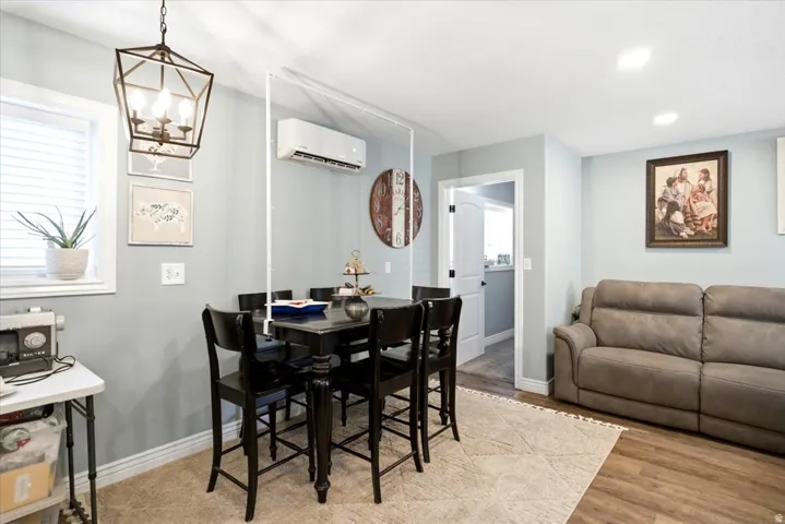 Open concept living area featuring wood-finish flooring, recessed lighting, and a window with blinds