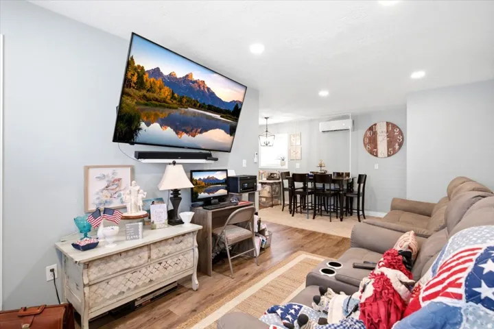 Open-concept living area with wood-finish flooring, recessed lighting, and a neutral wall palette