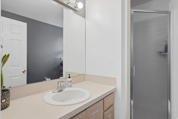 Bathroom vanity featuring a light-toned countertop with an integrated sink and chrome faucet