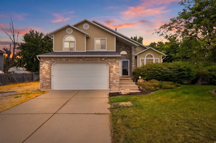 Two-story residence featuring a brick and stucco exterior, an attached two-car garage, and a concrete driveway