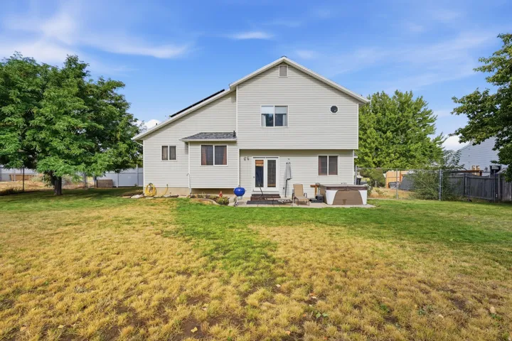 Expansive backyard featuring a large grass area and mature trees