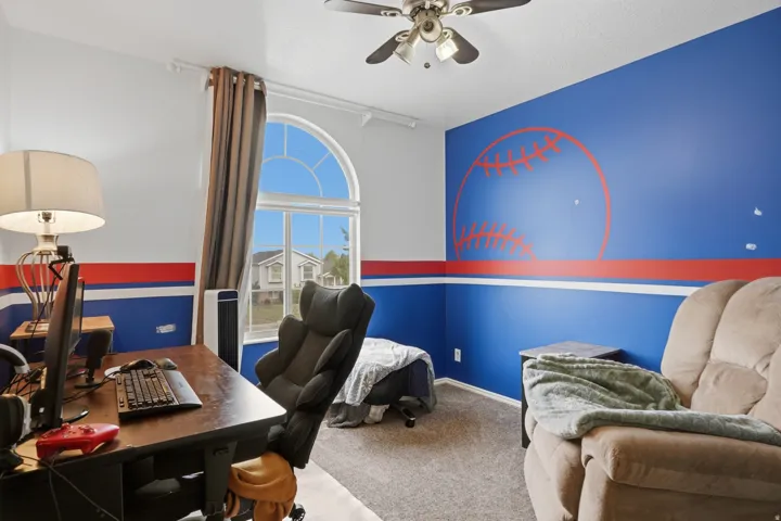 Room featuring an arched window, ceiling fan, and carpeted flooring