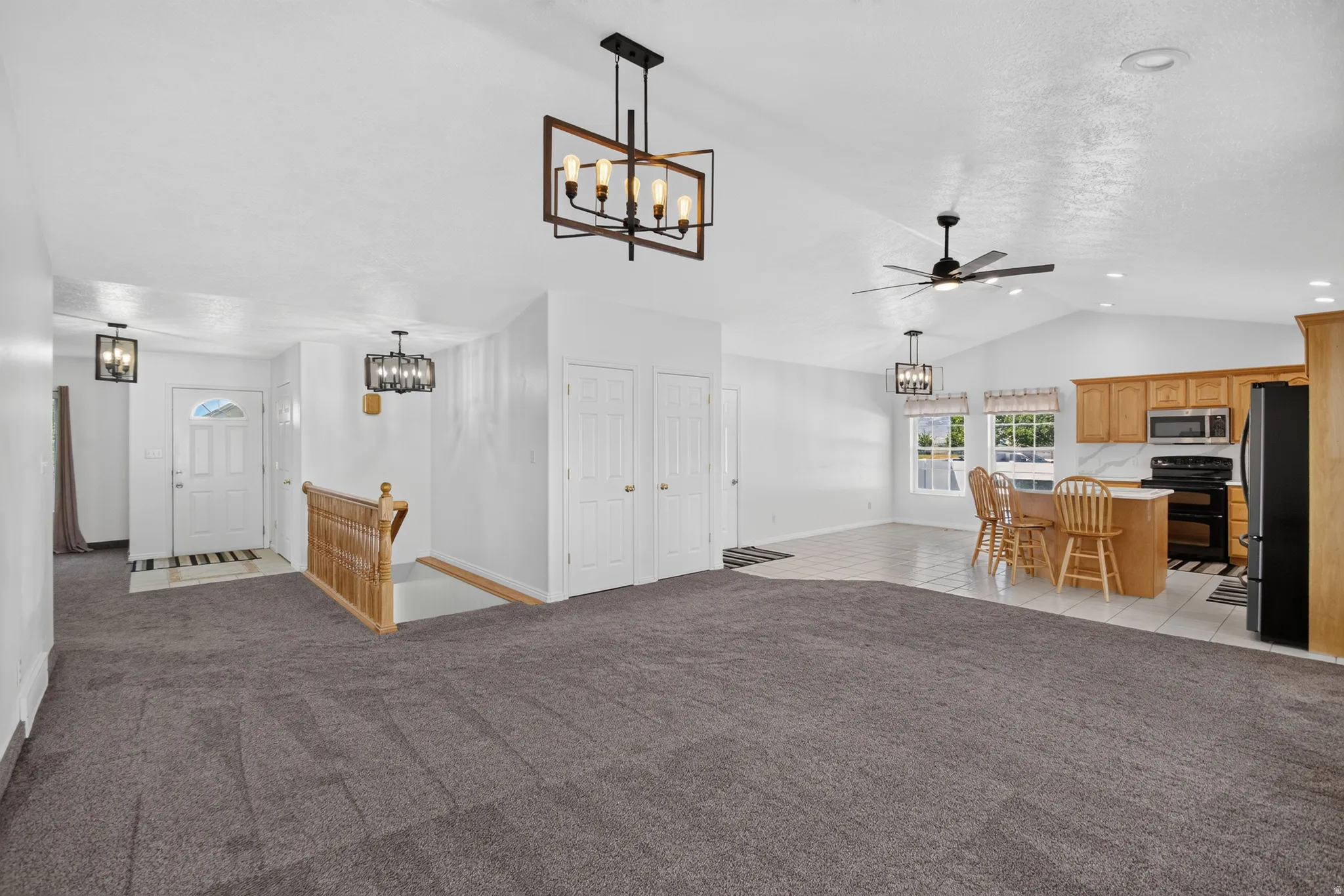 Open concept living area featuring vaulted ceilings, recessed lighting, and a modern ceiling fan