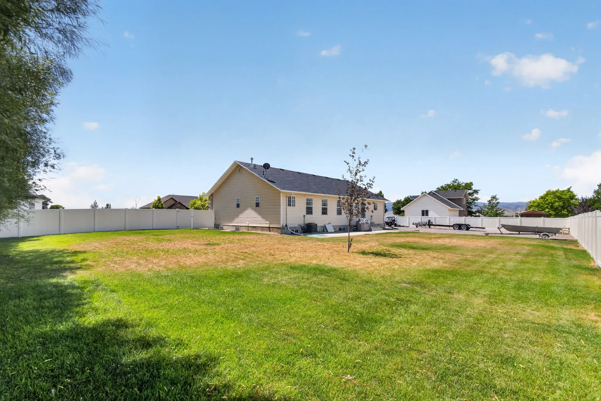 Expansive rear yard featuring a large lawn area and a full privacy fence