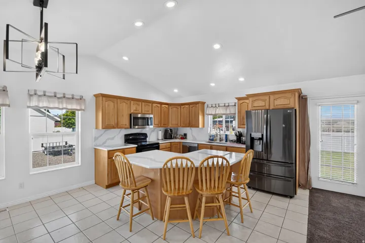 Kitchen featuring a central island with white countertop, wood cabinetry, and stainless steel appliances