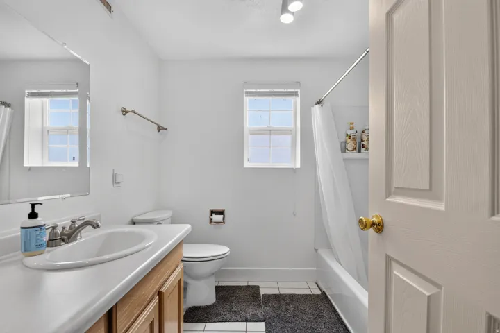 Bathroom featuring a single vanity with a white countertop and wood-finish cabinetry