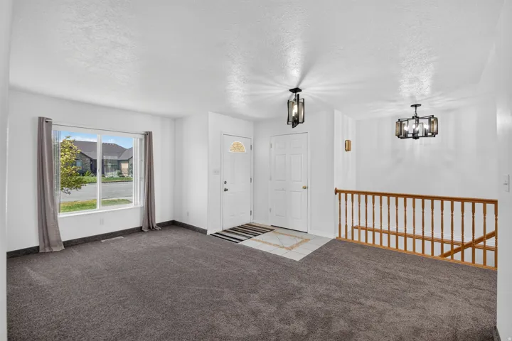 Entry foyer featuring a white paneled door with an arched glass insert, a second white paneled door, and a tiled entry mat
