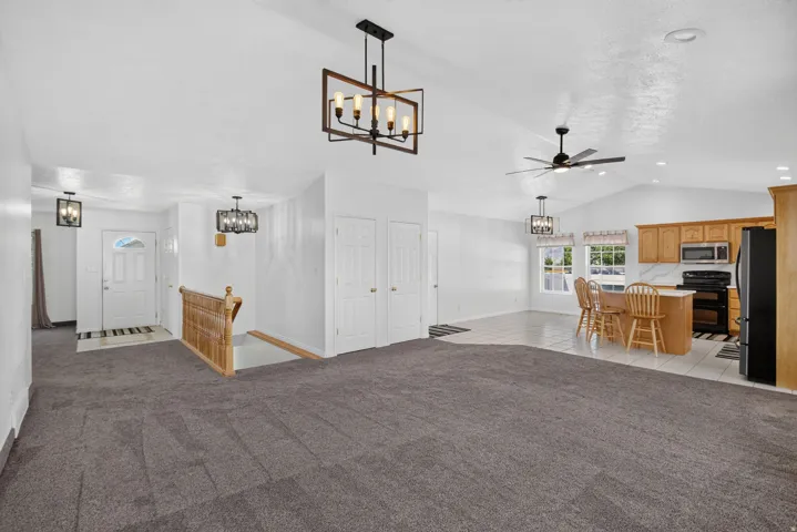 Open concept living area featuring vaulted ceilings, recessed lighting, and a modern ceiling fan