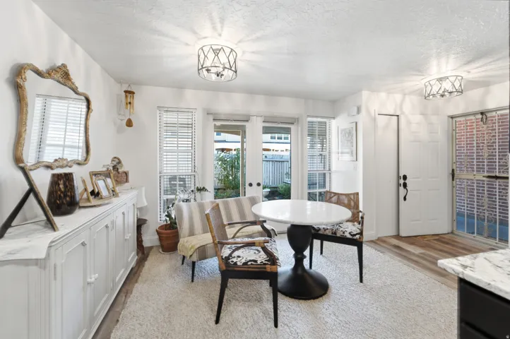 Living area featuring white walls, wood-finish flooring, and recessed lighting