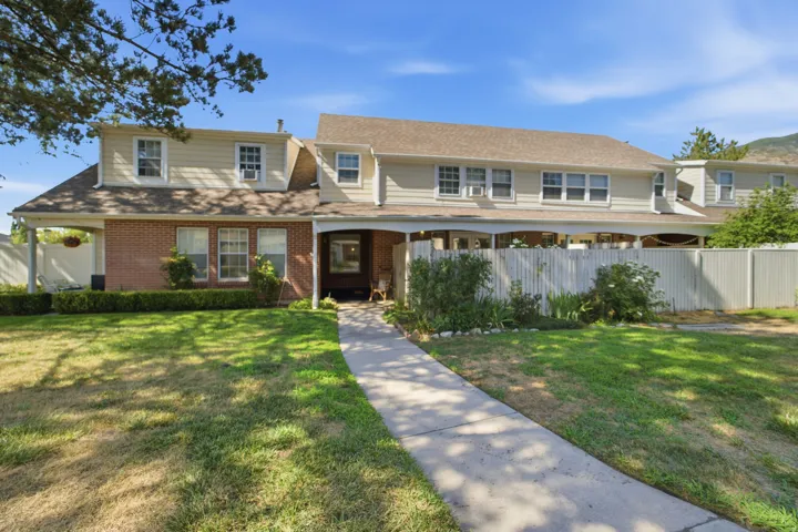 Multi-unit property featuring dormer windows, a covered entry, and a covered patio area