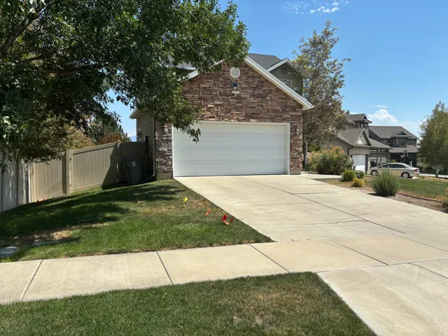 Front exterior featuring stone veneer siding, an attached two-car garage, and a concrete driveway