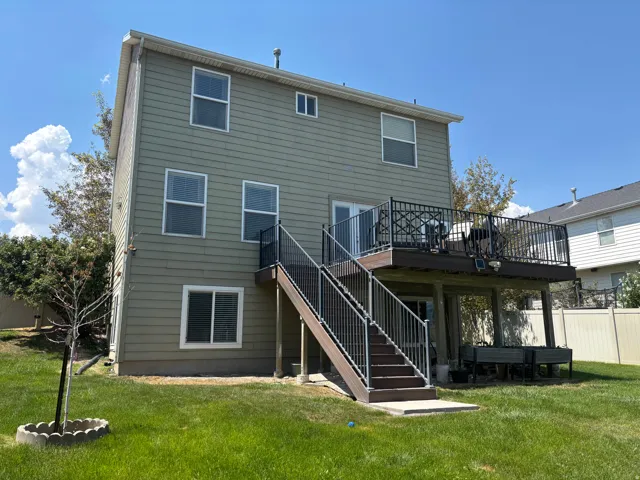 Two-story exterior featuring horizontal siding, multiple windows, and a large elevated deck with dark railings