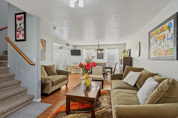 Open-concept living area featuring hardwood flooring, recessed ceiling lighting, and multiple seating zones