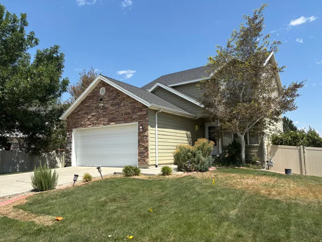 Exterior featuring stone veneer accents, horizontal siding, an attached two-car garage, and a concrete driveway