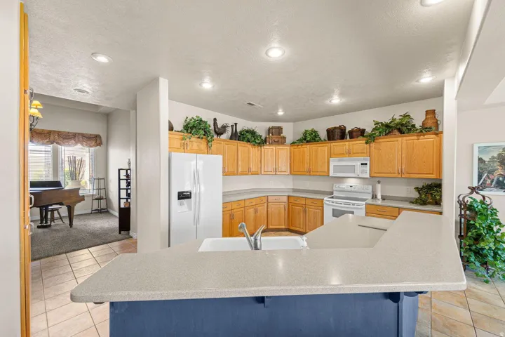 Kitchen featuring wood cabinetry, white appliances, and light-toned countertops