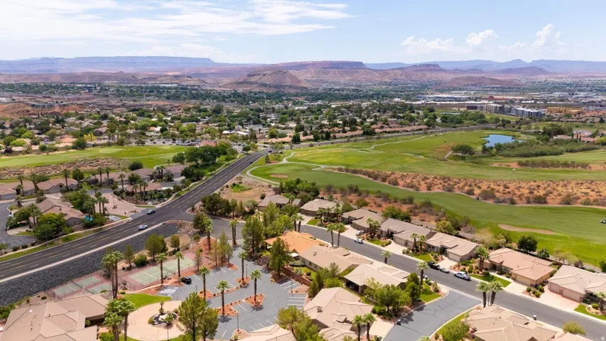 Expansive aerial view showcasing residential areas, green spaces, and distant mountains