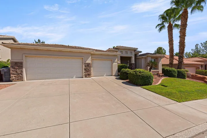Stucco exterior with stone accents and a concrete drive