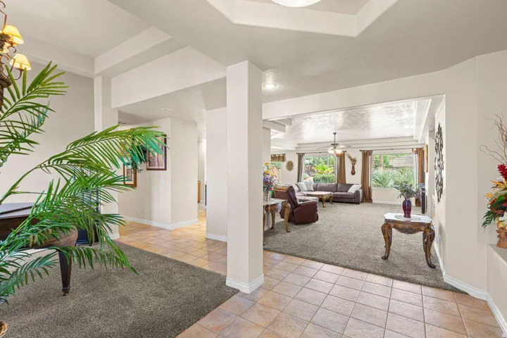 Entryway with tile flooring and contrasting carpeted living area