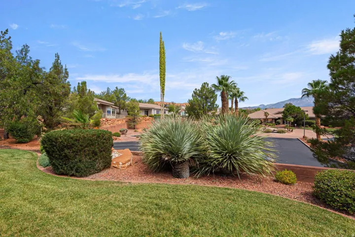 Manicured lawn with mature landscaping, featuring desert plants and established trees
