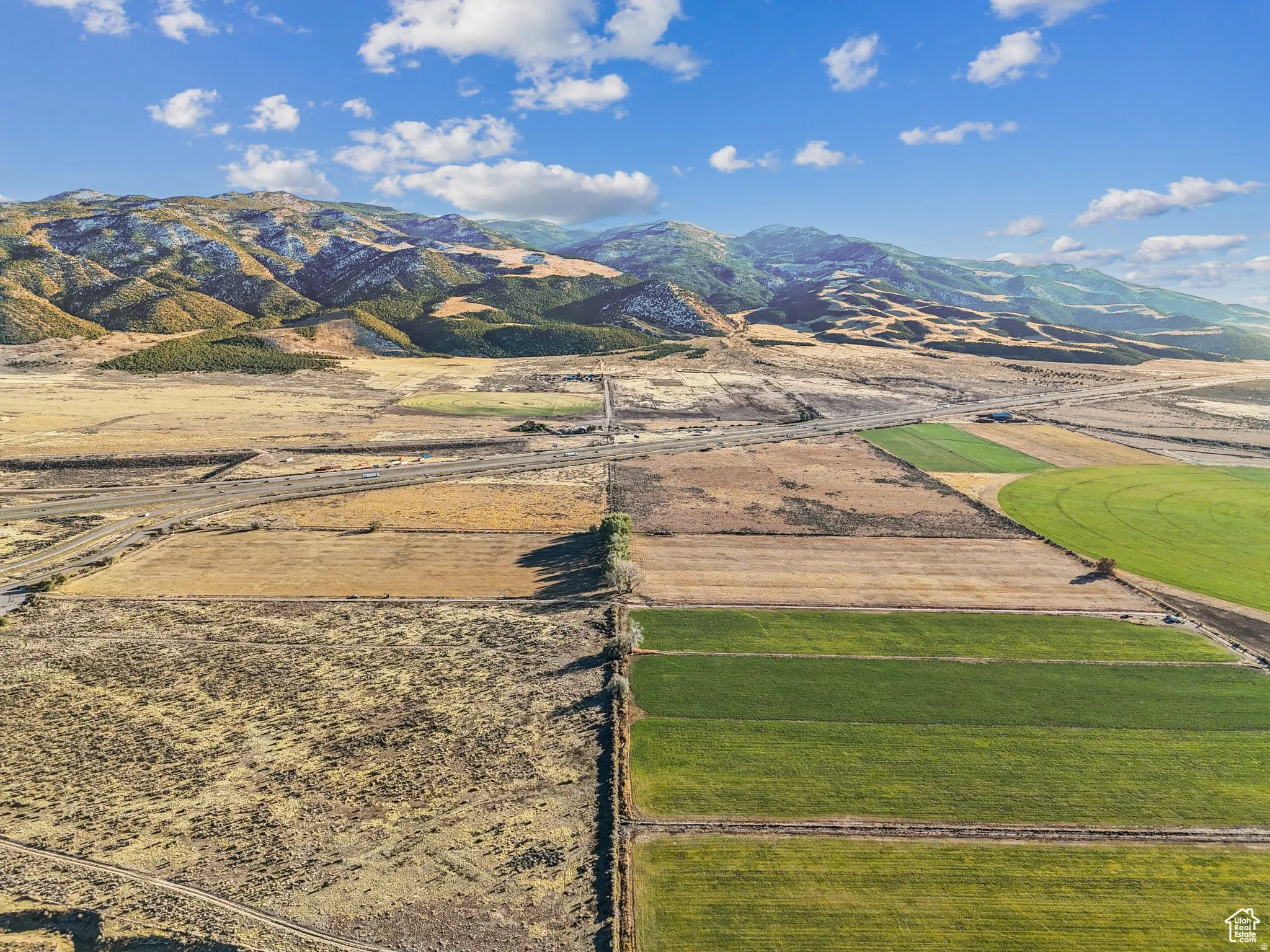 Expansive agricultural acreage featuring diverse fields and mountainous backdrops