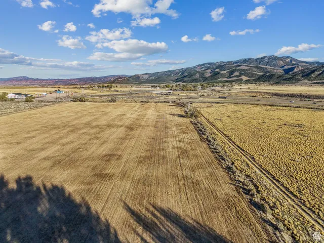 Expansive agricultural land featuring a tilled field and natural grasses