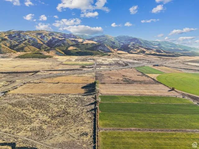 Expansive agricultural acreage featuring diverse fields and mountainous backdrops
