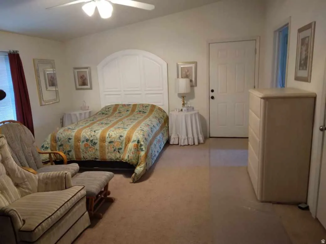 Vaulted ceiling, ceiling fan, paneled accent wall, neutral wall paint, white interior door