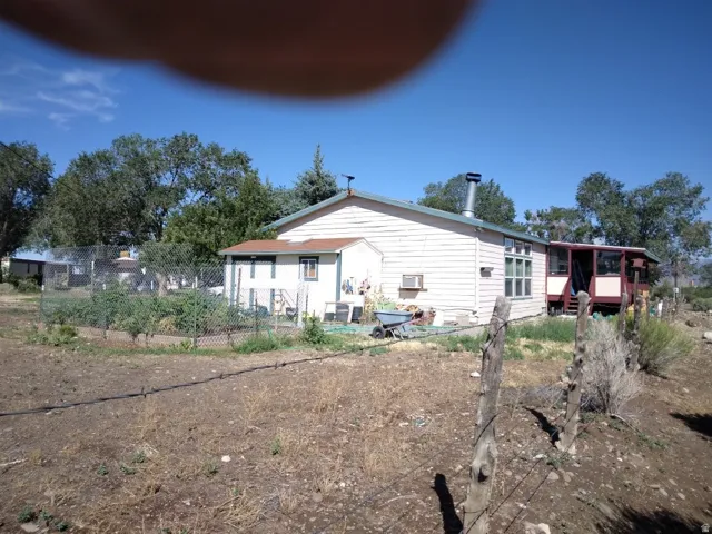 Rear exterior with siding, enclosed porch, and raised garden beds