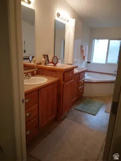 Dual vanity with wood-finish cabinetry, integrated sinks, and individual mirrors