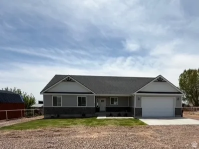 Contemporary ranch-style residence featuring a gray siding and stone veneer facade