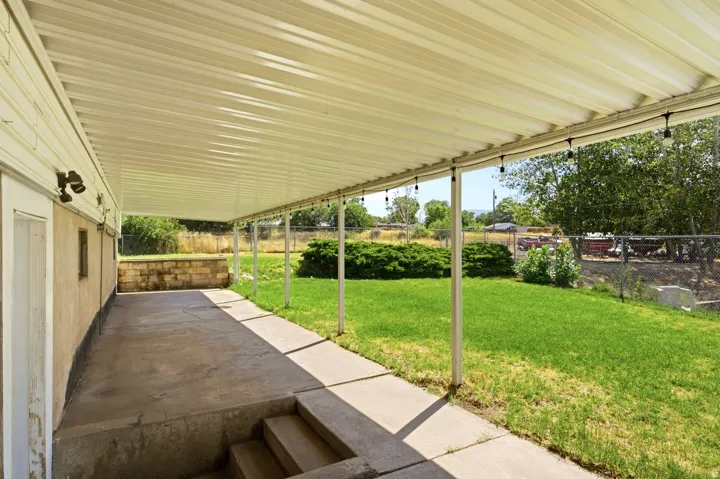 Expansive covered patio featuring a corrugated metal roof and string lighting