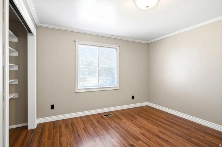 Interior room with wood-finish flooring, neutral wall paint, and white trim