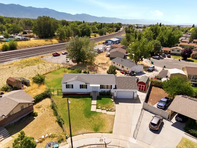 Ranch-style residence featuring a prominent front lawn and a paved driveway leading to an attached garage