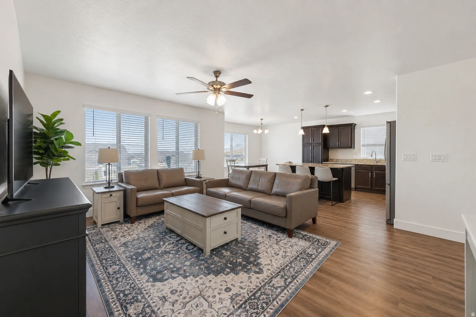 Open-concept living area featuring wood-finish flooring, recessed lighting, and a ceiling fan