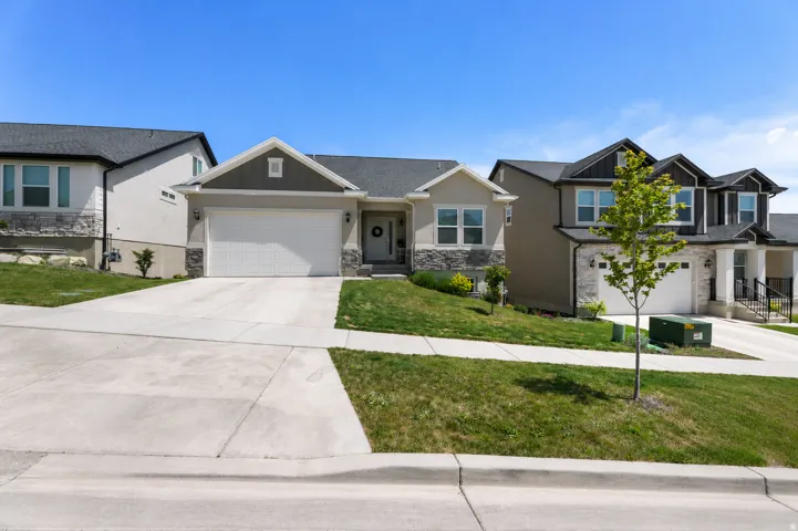 Contemporary ranch-style residence featuring a two-car garage, concrete driveway, and stone accents