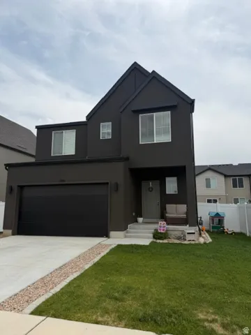 Modern exterior featuring dark stucco siding with contrasting white window frames and black trim