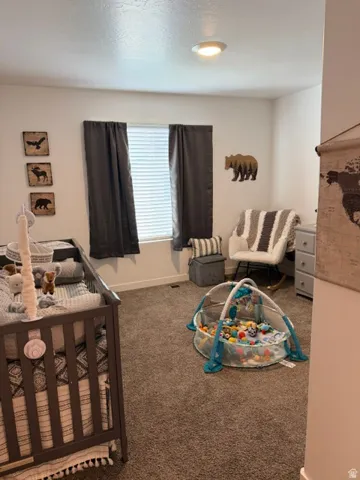 Carpeted room featuring a single window with blinds, recessed lighting, and white walls