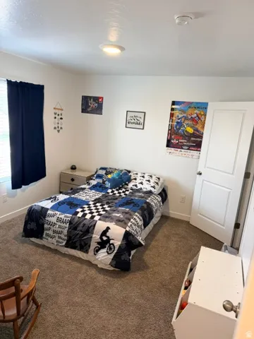 Carpeted room featuring white walls and a ceiling-mounted light fixture