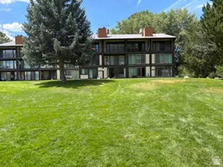 Multi-story building featuring dark-toned exterior siding, expansive windows, multiple balconies, and visible chimney structures