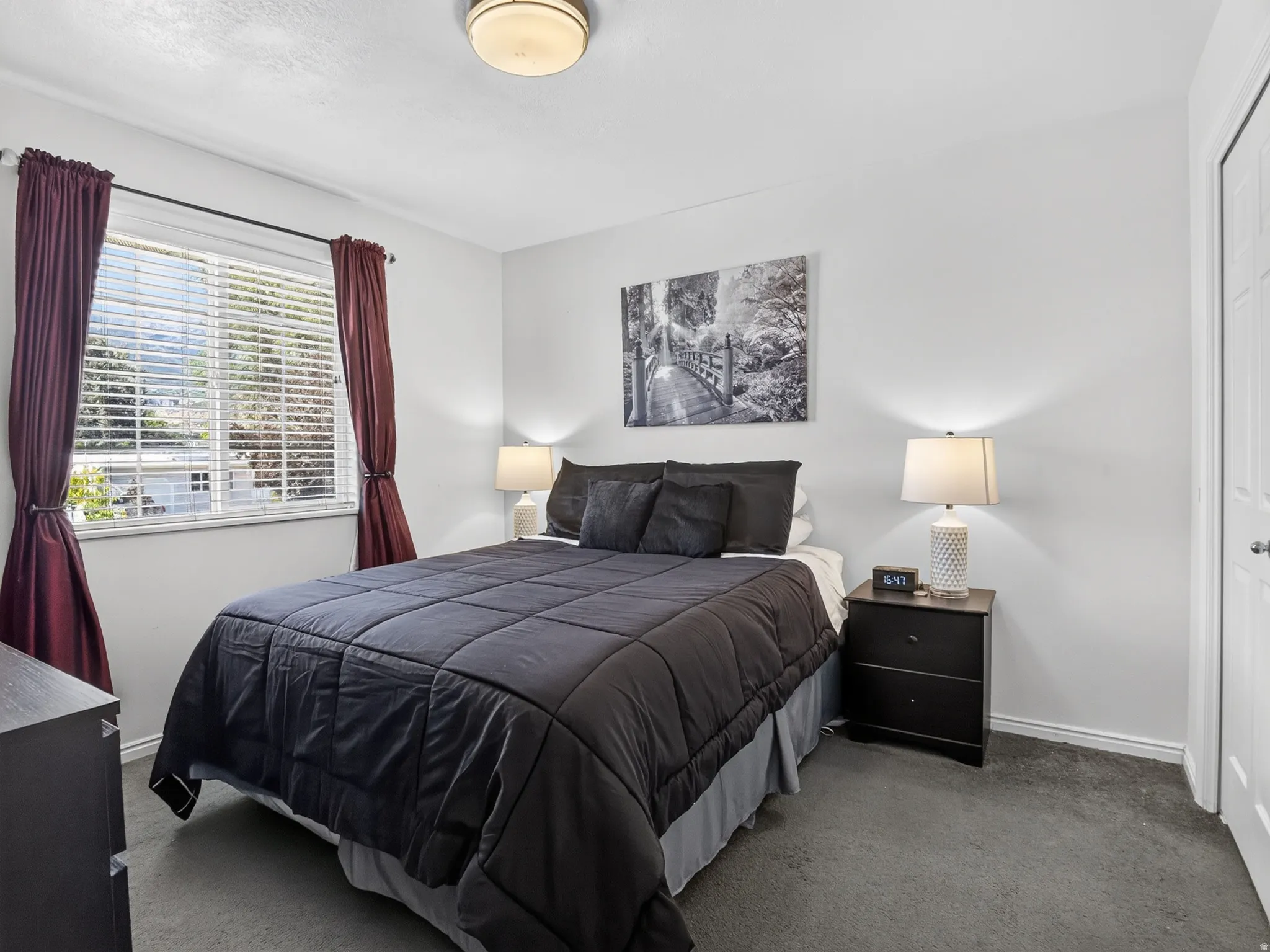 Second bedroom featuring neutral wall paint, carpet flooring, a window with blinds, and a white paneled door