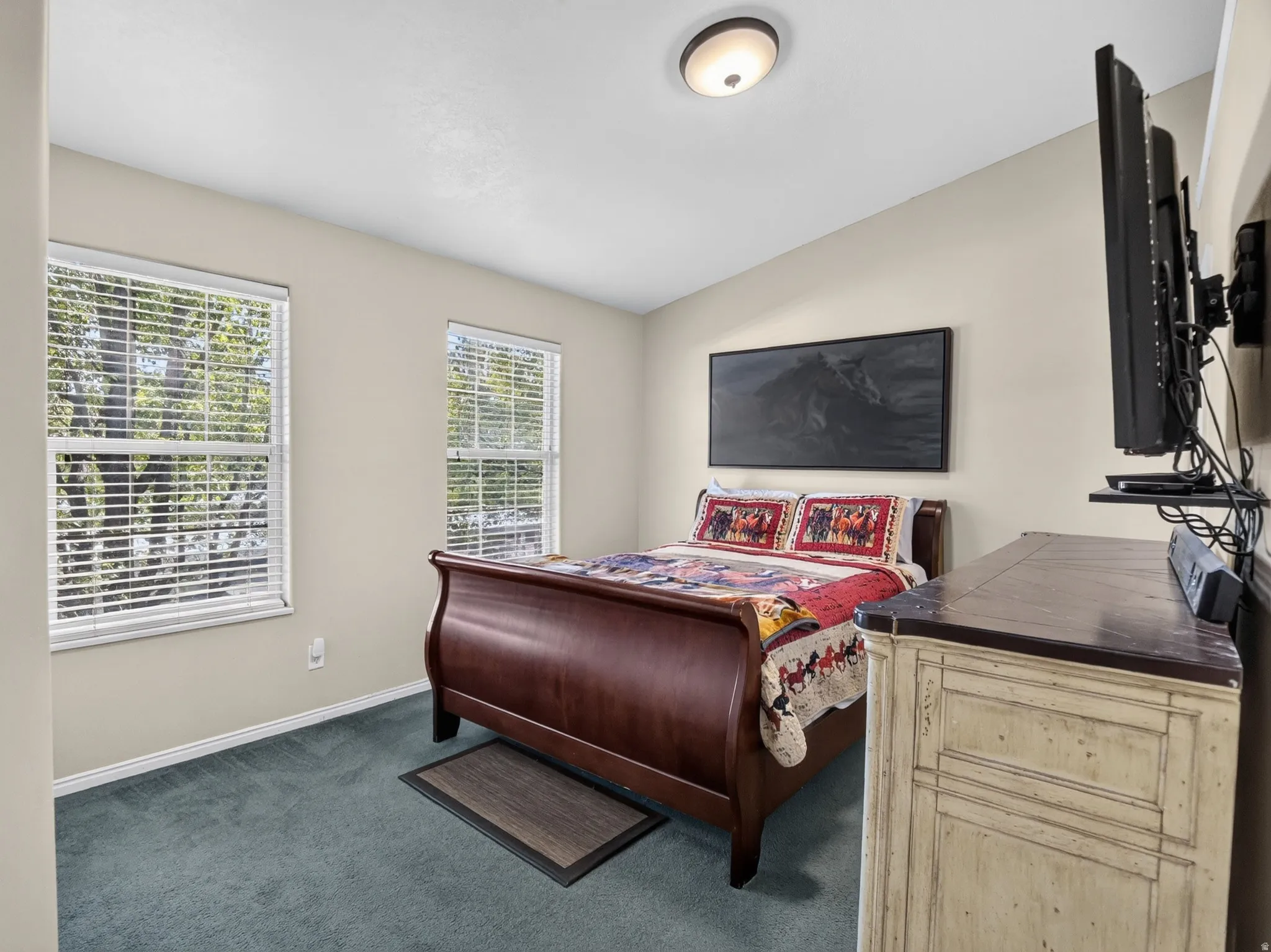 Master Bedroom featuring two windows with white blinds, light beige walls, and blue carpet flooring