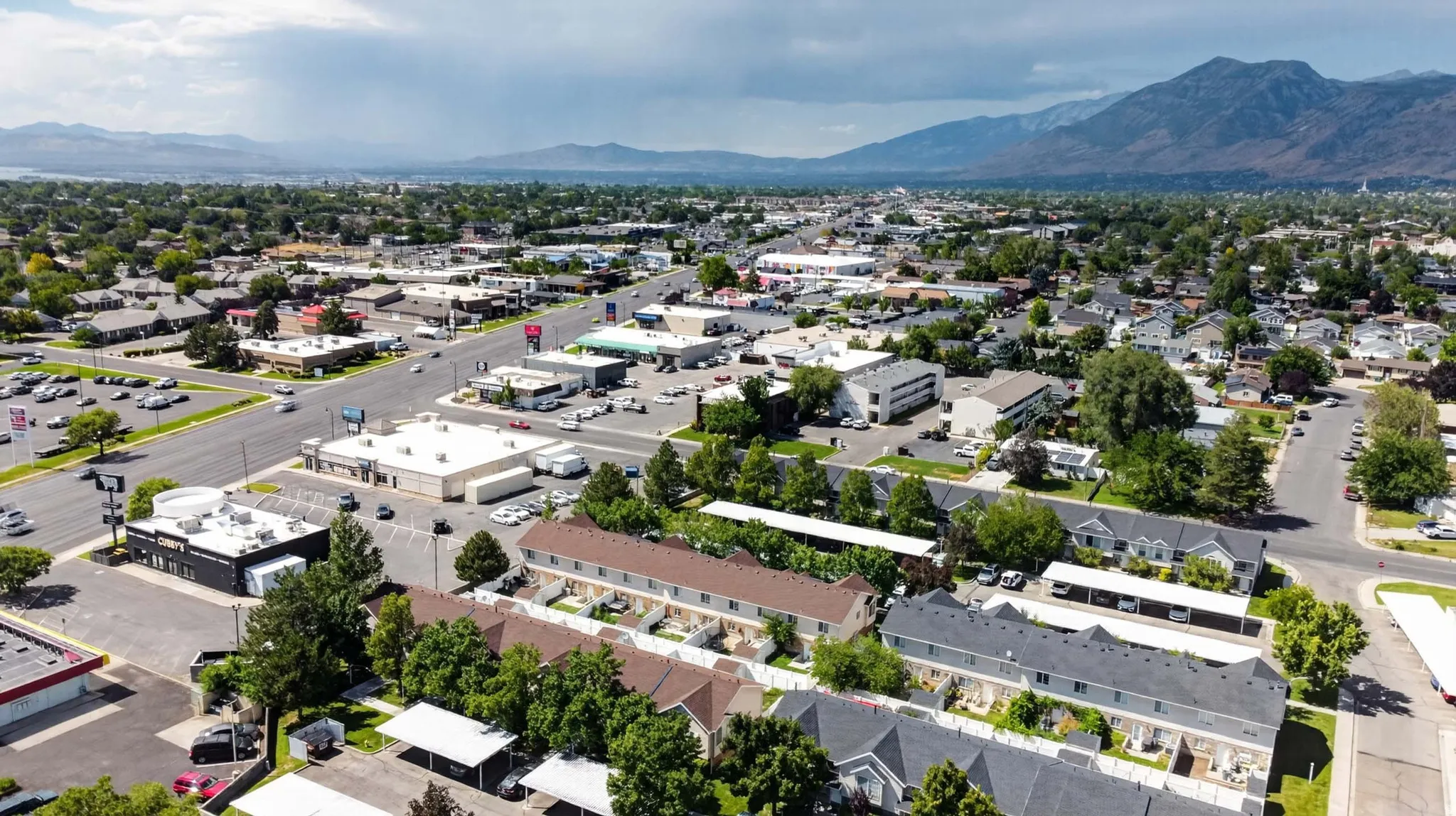 Aerial perspective showcasing a mixed-use neighborhood with commercial properties, multi-family residences, and single-family homes