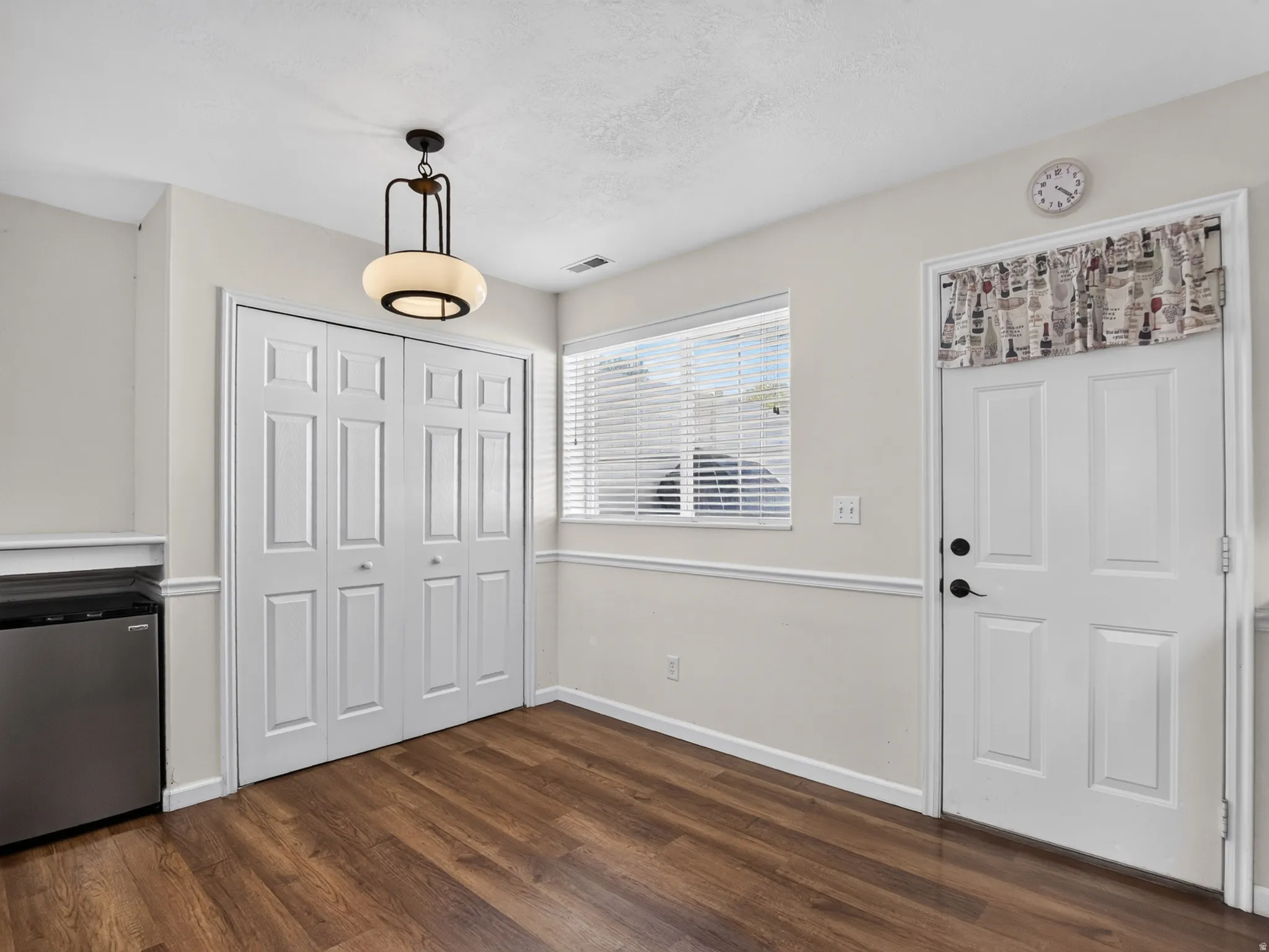 Interior space featuring large pantry, wood-finish flooring, backdoor to the patio and a contemporary ceiling light fixture