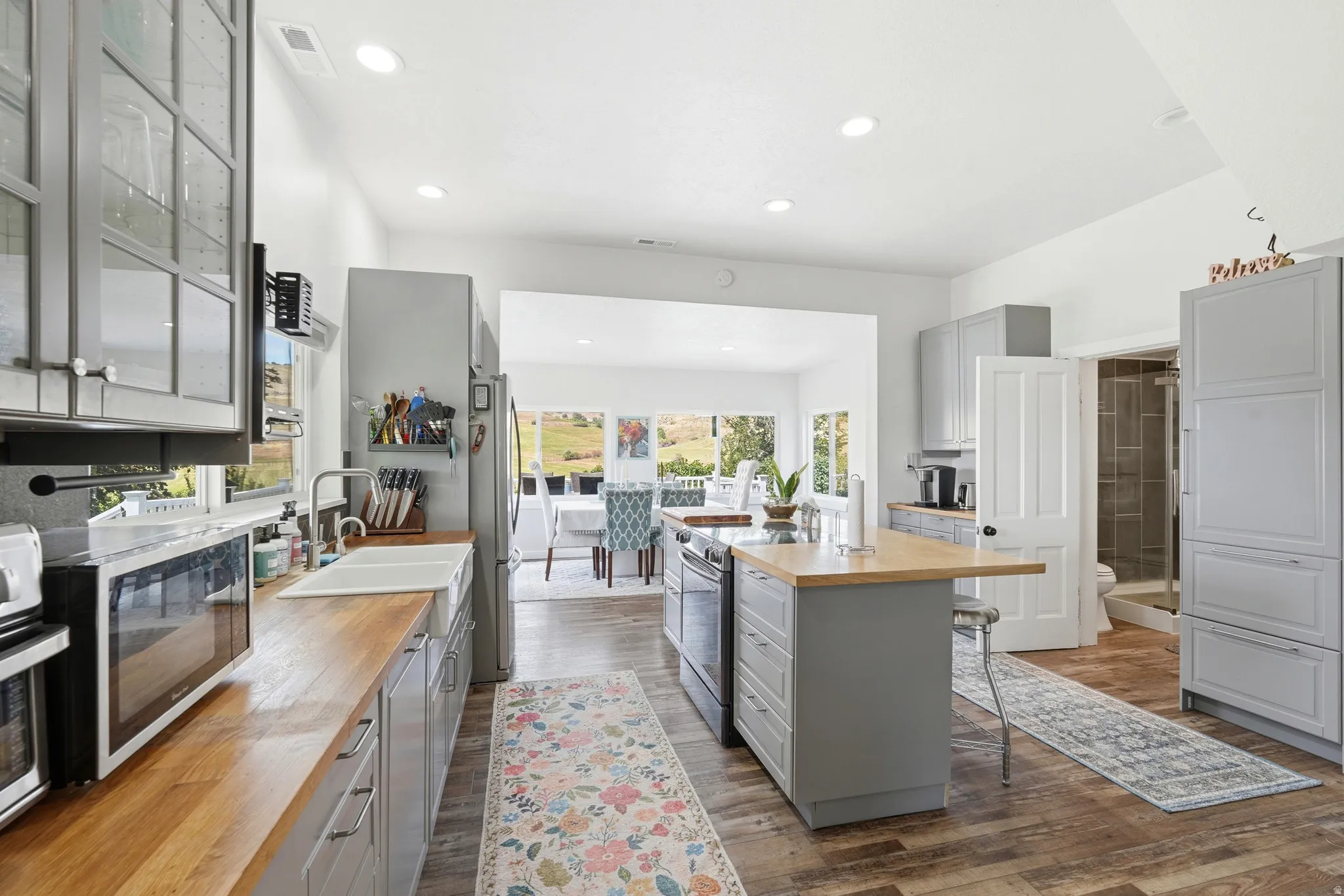 Spacious kitchen featuring wood-finish flooring and light gray cabinetry