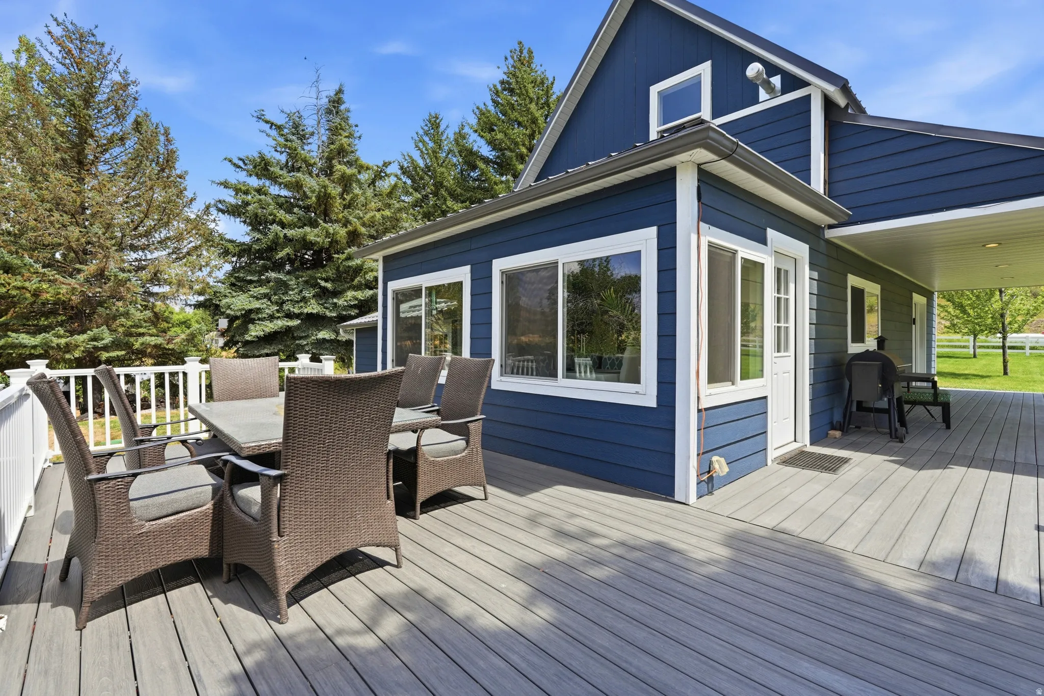 Spacious composite decking featuring a white railing and covered section