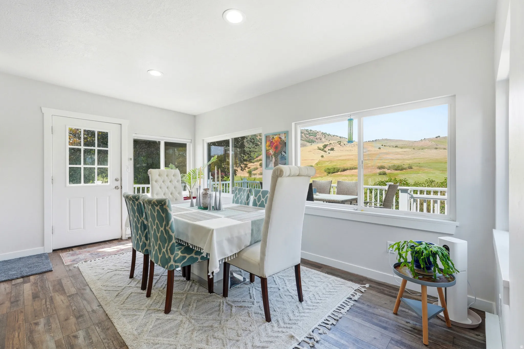 Dining area with wood-finish flooring, recessed lighting, and a glass-paned door