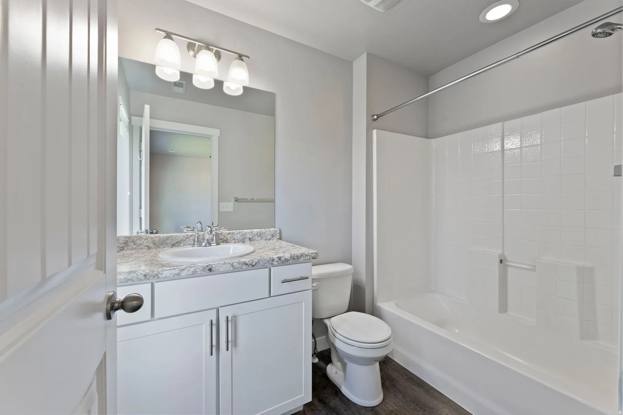Primary bathroom featuring a white vanity with a light-colored countertop, undermount sink, and chrome faucet