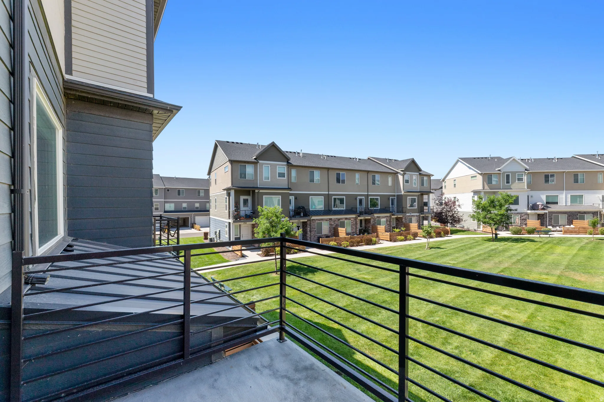 Private balcony featuring concrete flooring and a linear metal railing