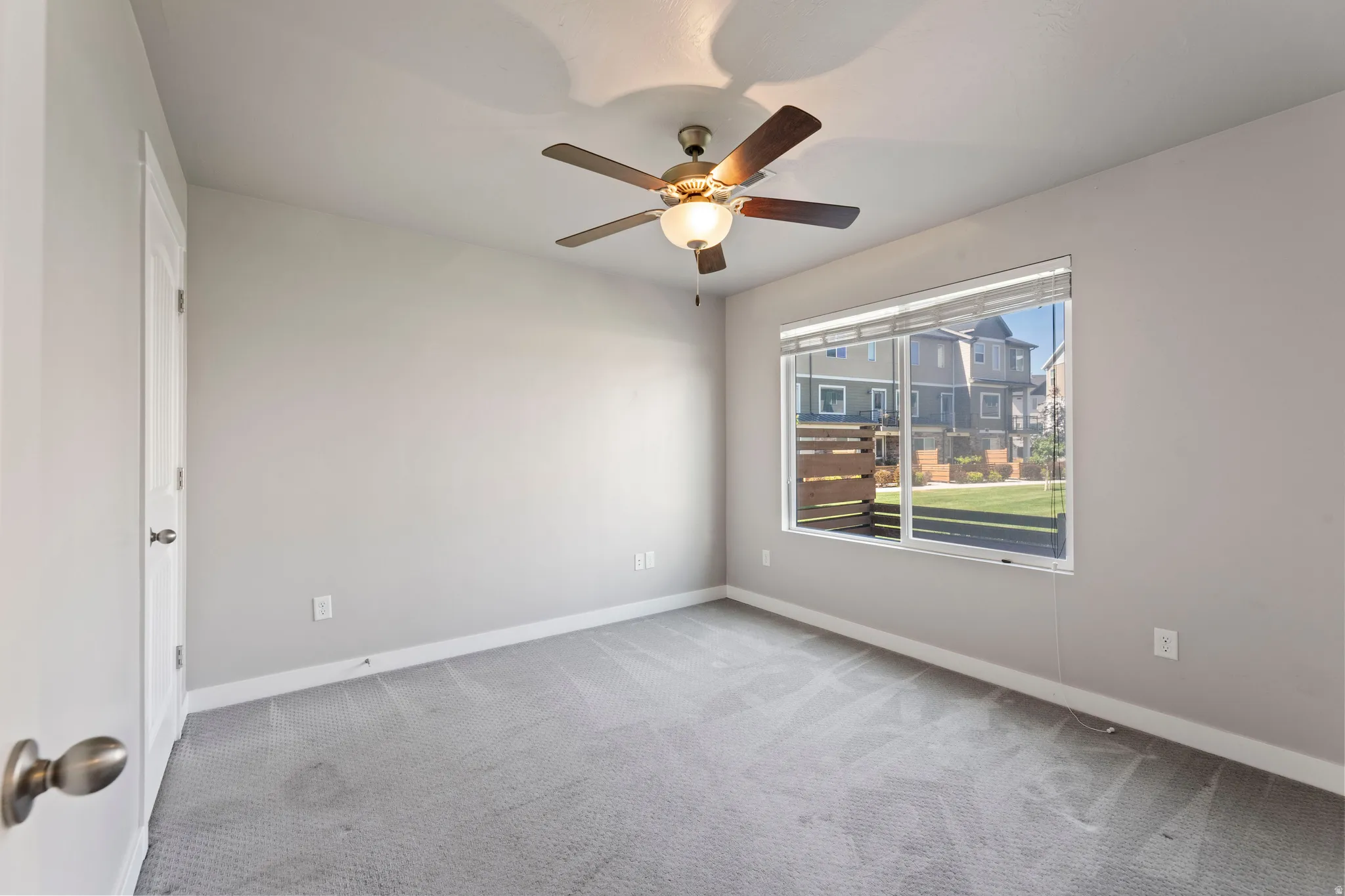 1st floor Carpeted bedroom featuring a ceiling fan with integrated lighting, a large window with blinds, and light-toned walls