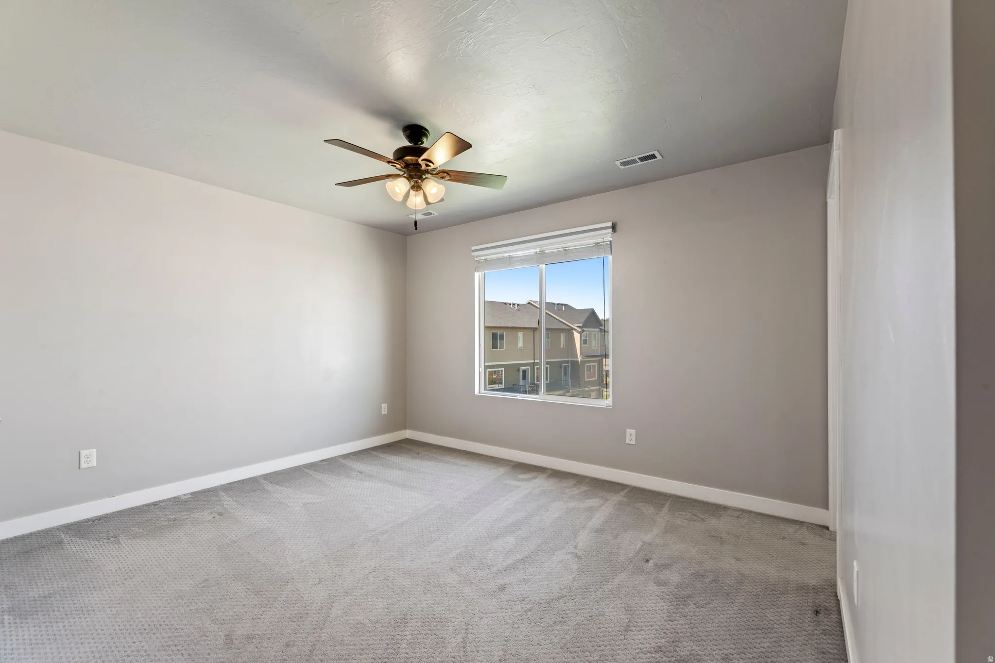 Spacious room featuring neutral carpeting and light gray wall paint